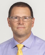 Head-and-shoulder portrait of website author, Steve Kifowit, wearing light purple shirt and yellow tie.